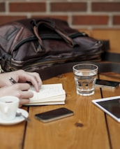 A casual meeting around a wooden table with laptops, coffee cups, and brainstorming notes.