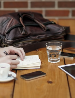 A casual meeting around a wooden table with laptops, coffee cups, and brainstorming notes.
