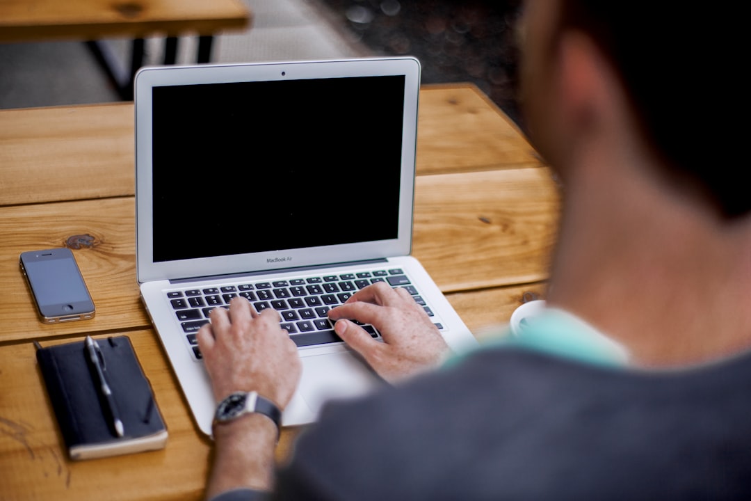 man using MacBook Air, man typing on laptop