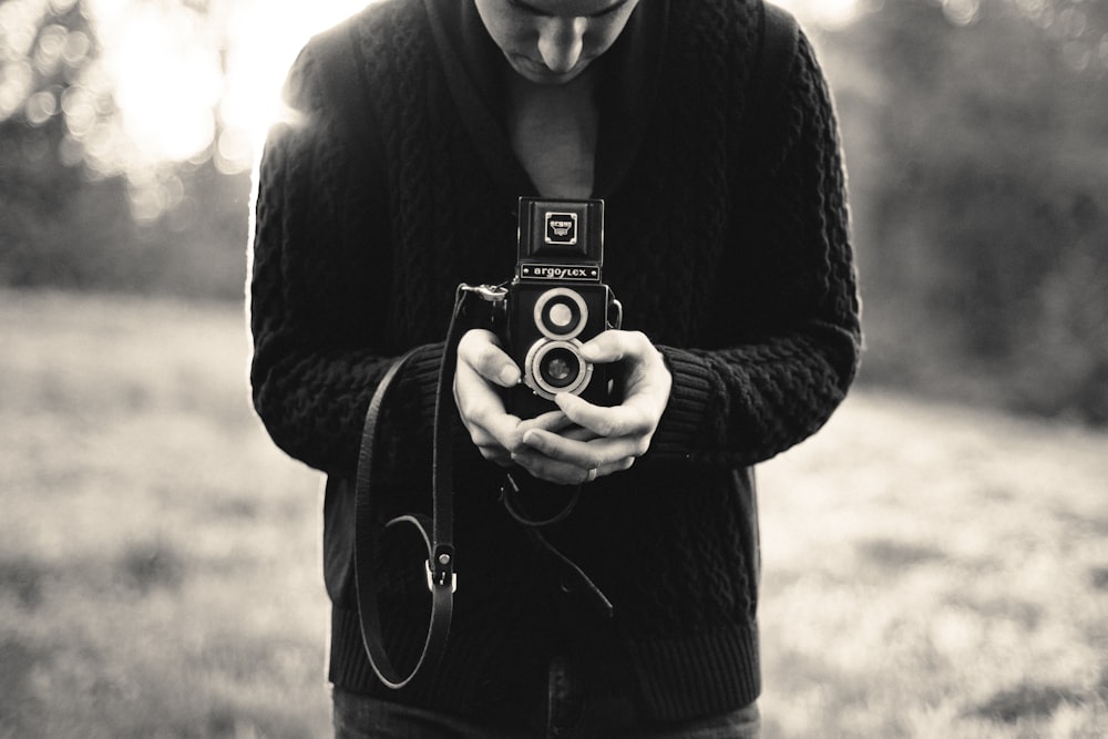 person holding double-lens camera