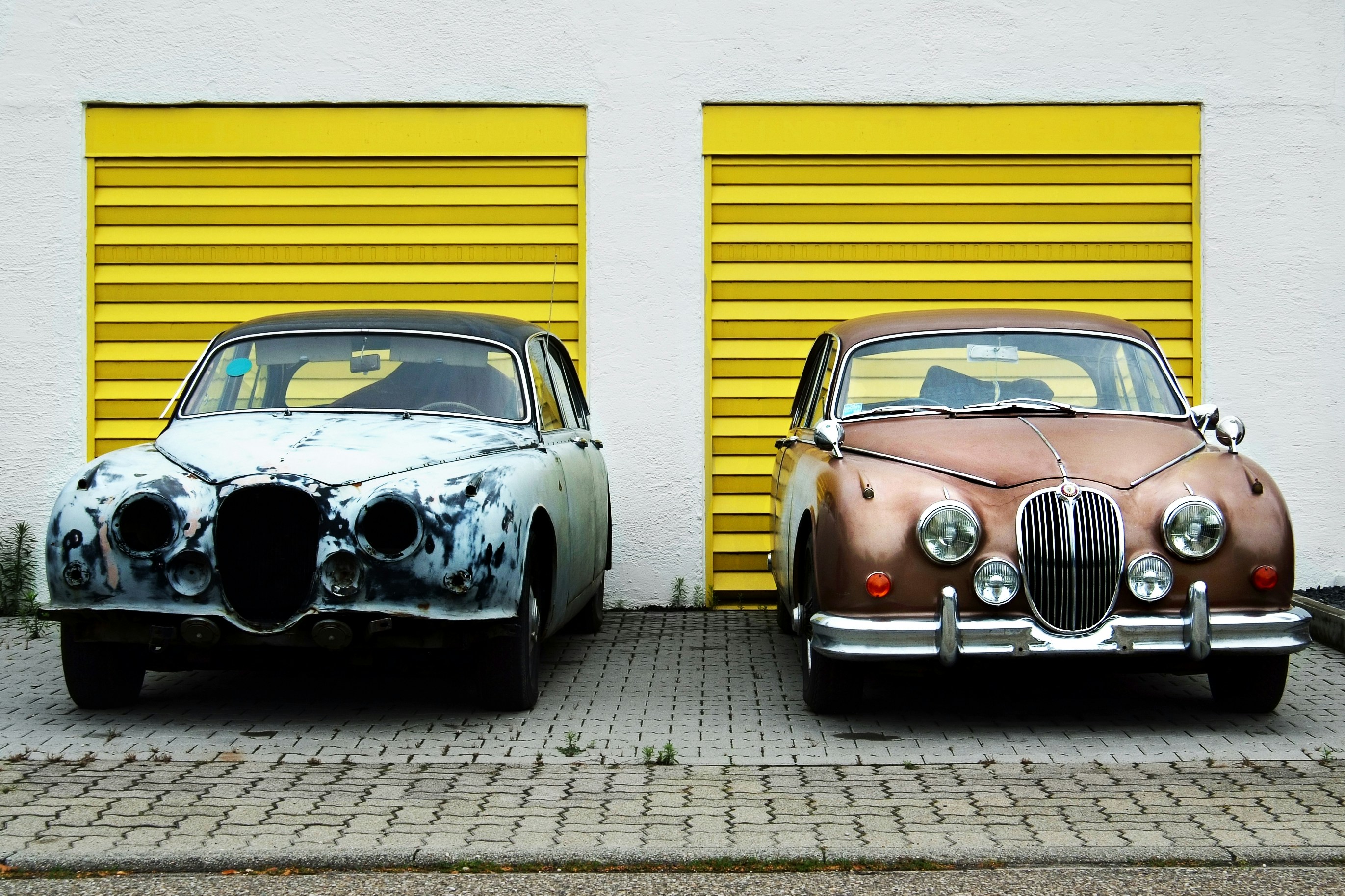 Retro cars in front of yellow garage