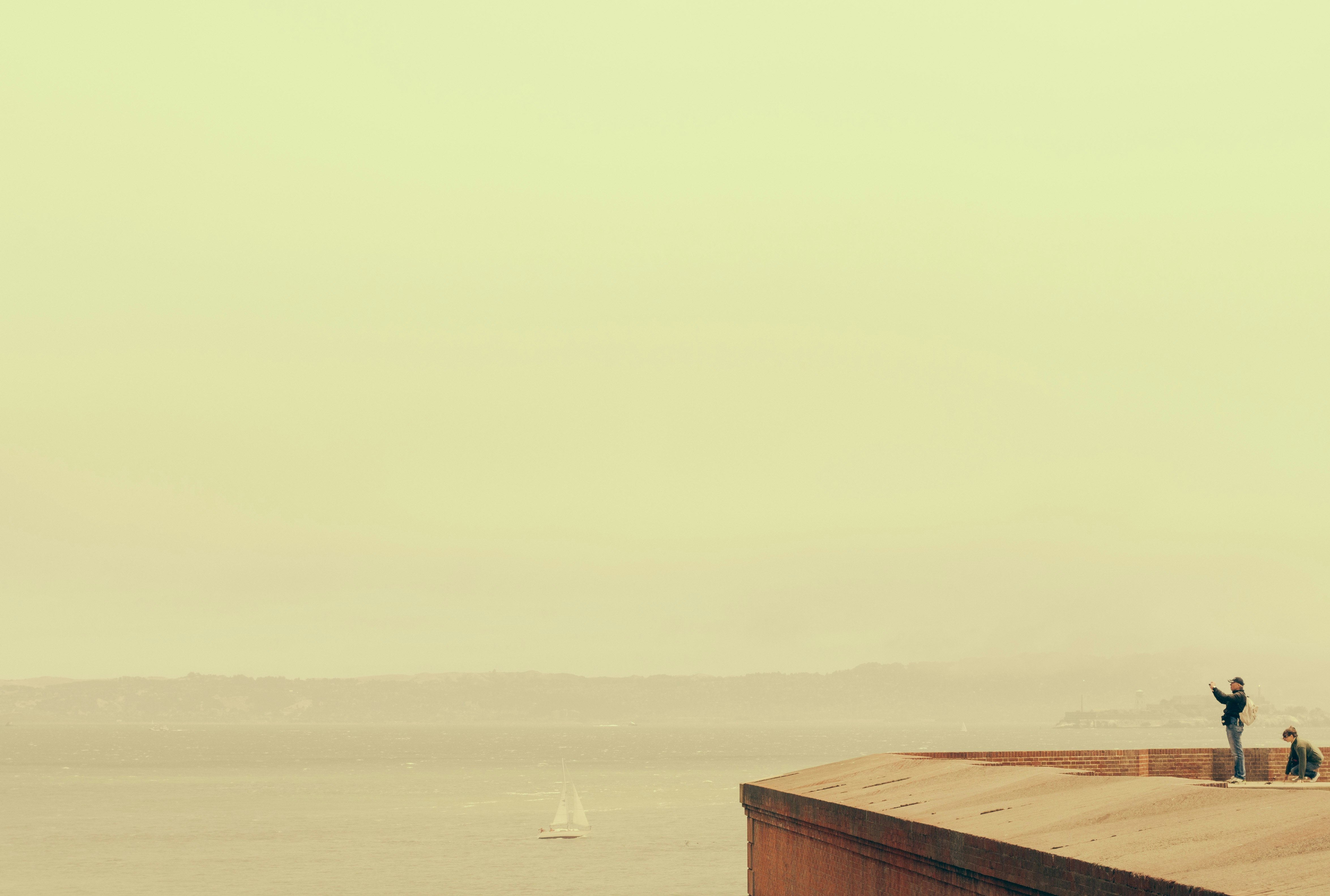 two people standing and sitting on rooftop