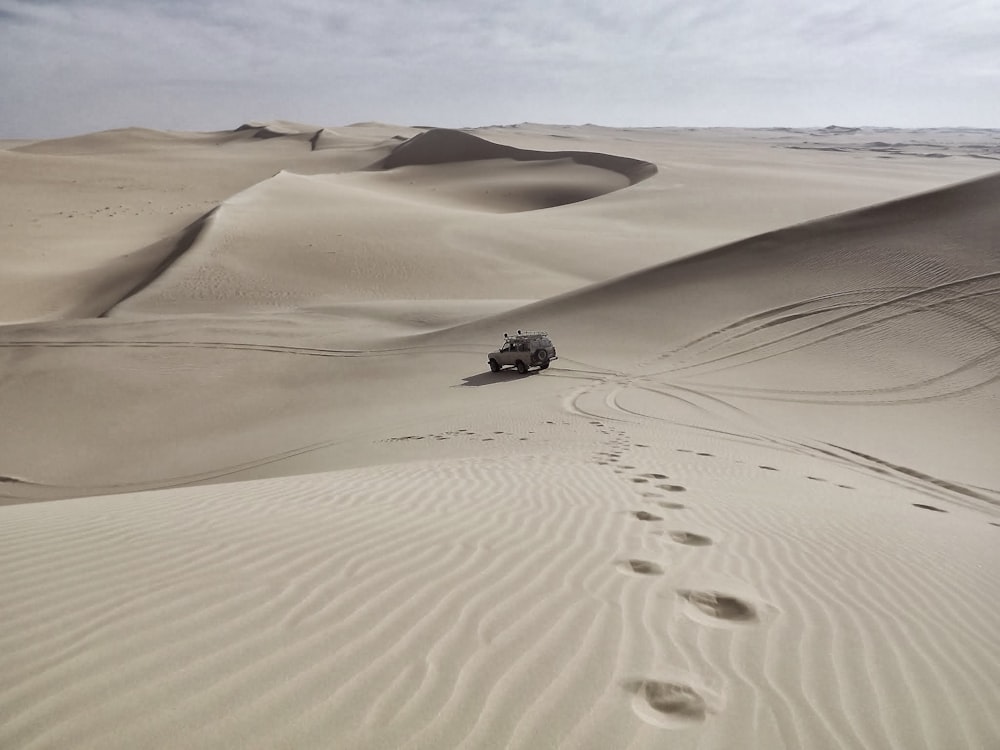 veículo marrom na areia durante o dia