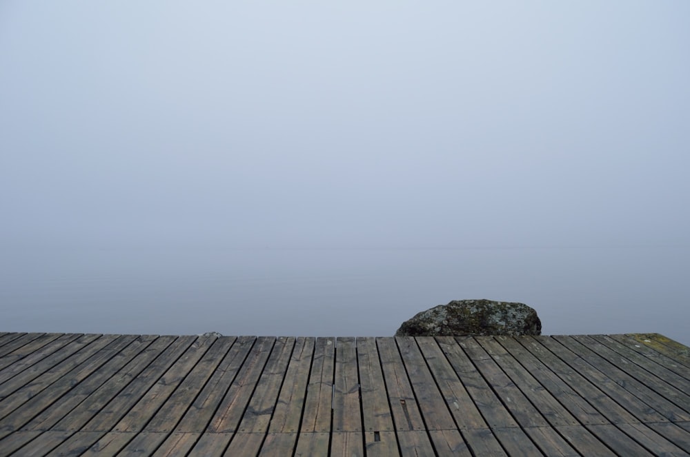 Muelle de madera marrón en tiempo de niebla durante el día