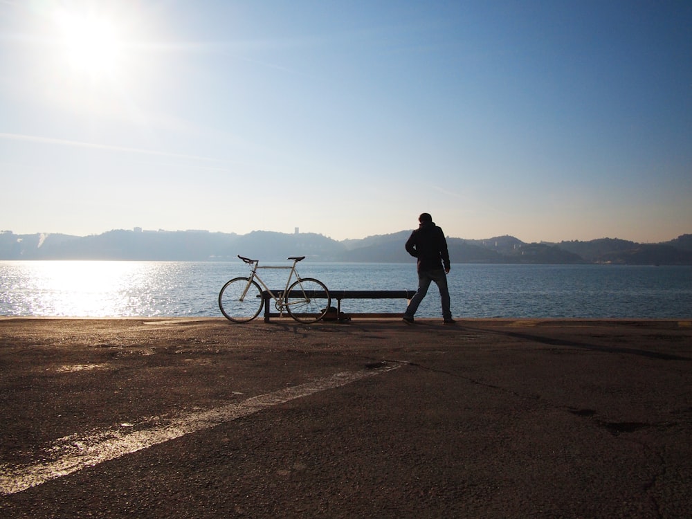 Persona che si leva in piedi accanto alla bicicletta della città