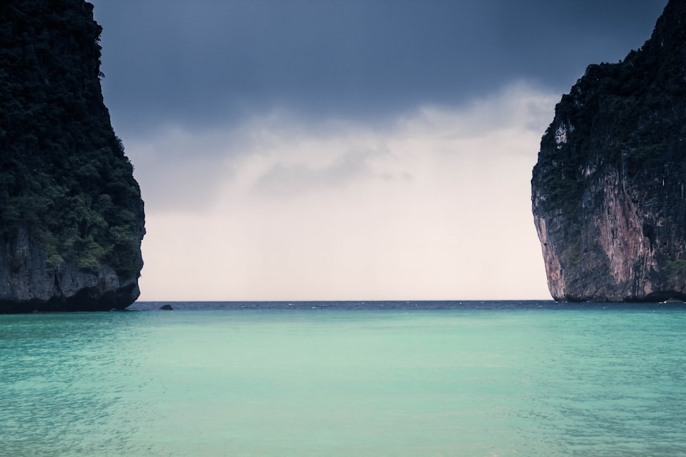 specchio d'acqua con di due formazioni rocciose durante il giorno