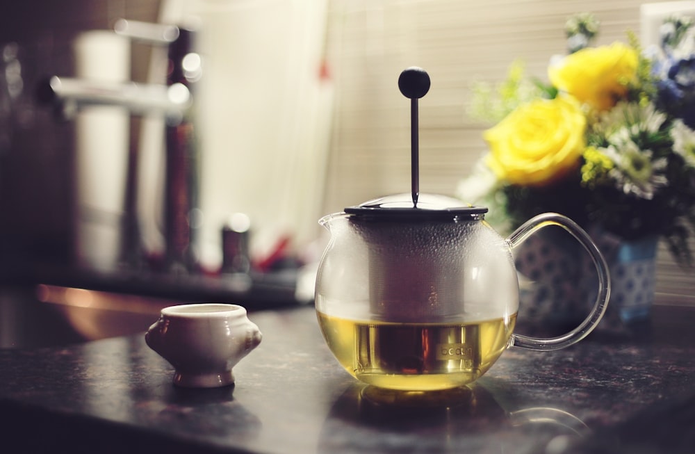 teapot filled with yellow liquid on table