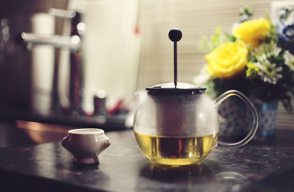 tetera llena de líquido amarillo sobre la mesa