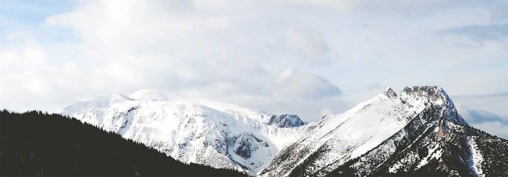 montanha coberta de neve sob nuvens brancas durante o dia