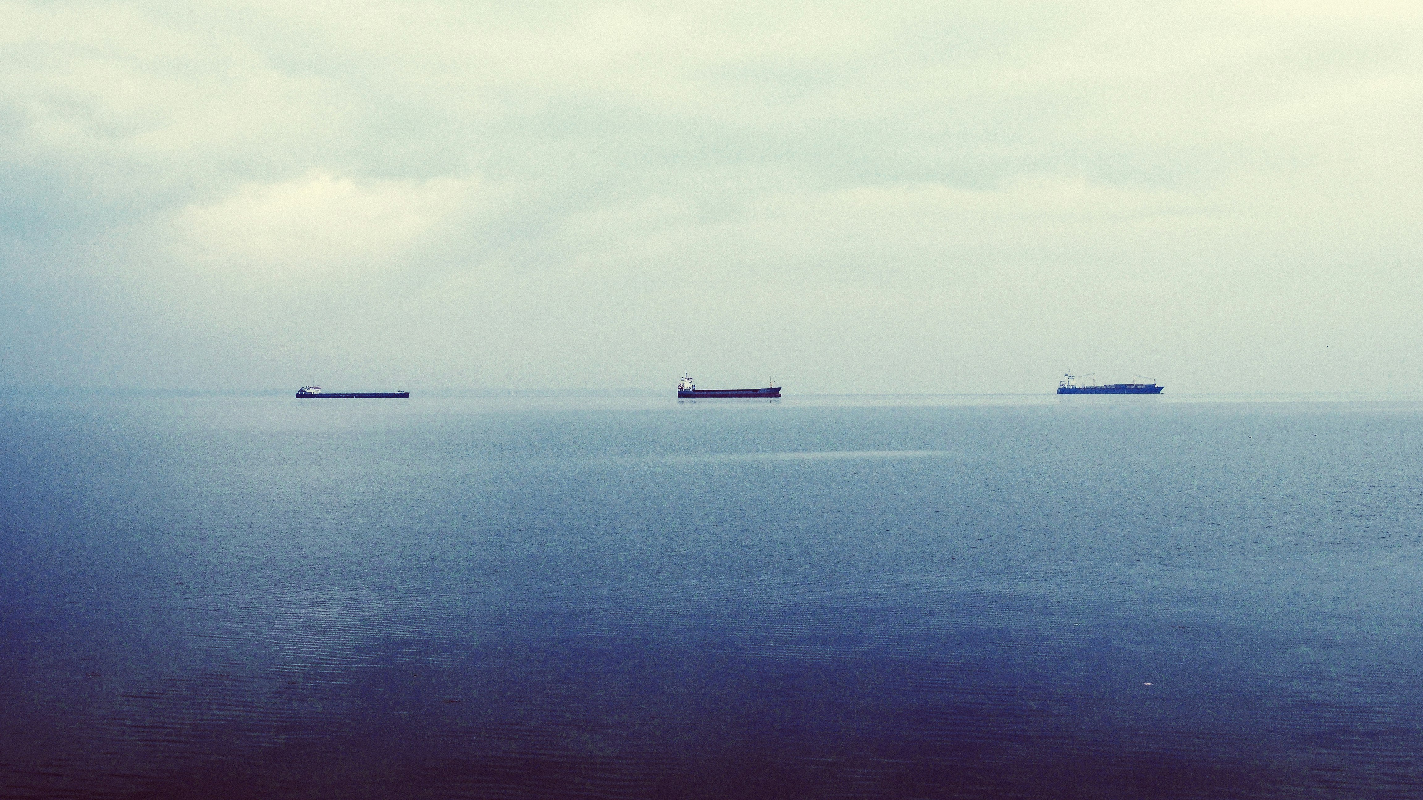 three ship on calm body of water