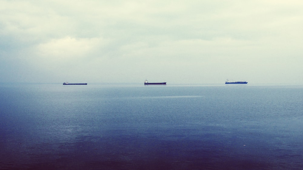 three ship on calm body of water