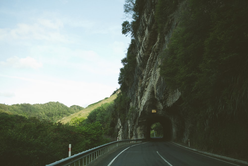 road beside mountain with tunnel