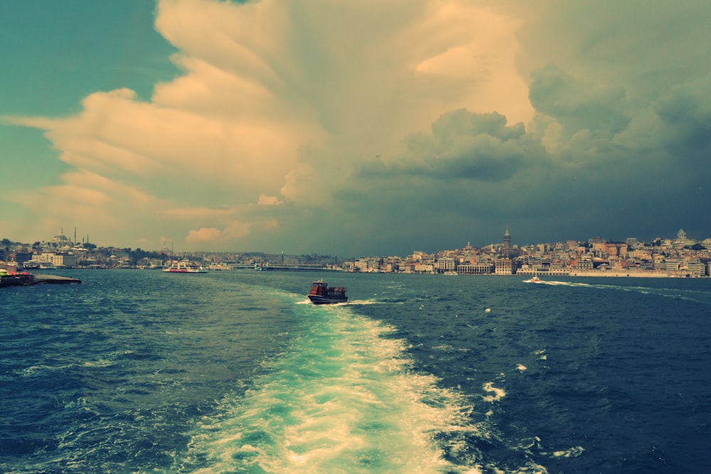 boat on body of water under cloudy blue sky