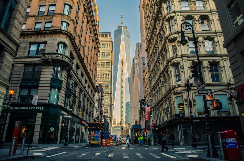 down view of white and blue glass tower in between buildings during daytime