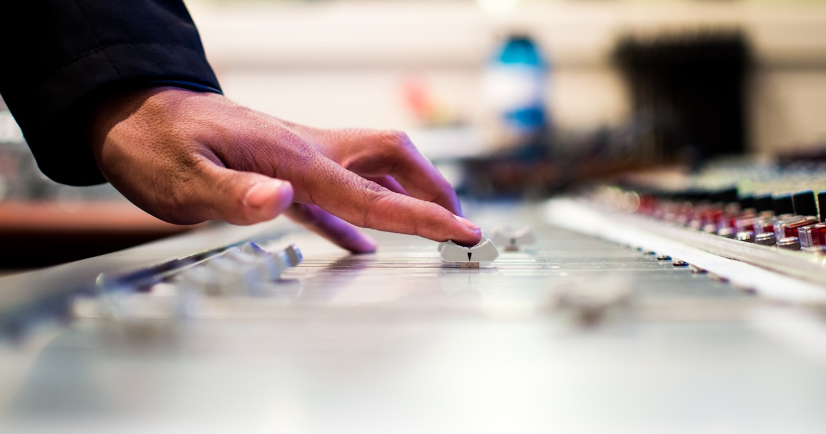 Adjusting dials on a mixer by Uniphonic person holding mixing console