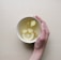 person holding white bowl with sliced lime and ginger inside