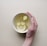 person holding white bowl with sliced lime and ginger inside
