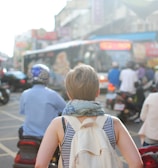 woman wearing backpack walking on road