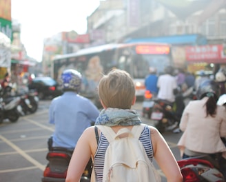 woman wearing backpack walking on road