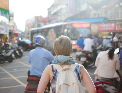 woman wearing backpack walking on road