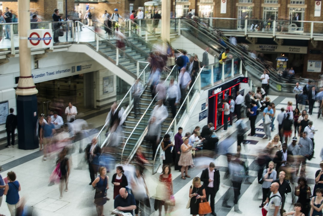 people standing and walking on stairs in mall, London Underground atrium