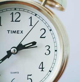 round Timex analog clock at 2:33