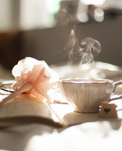 teacup on book beside pink flower decor