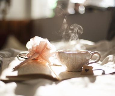 teacup on book beside pink flower decor
