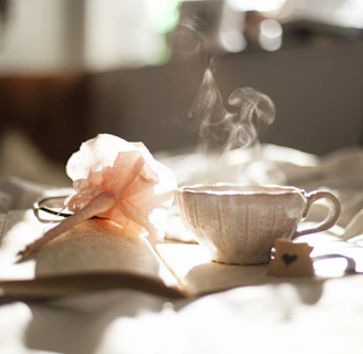 teacup on book beside pink flower decor