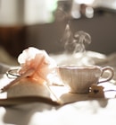 teacup on book beside pink flower decor