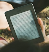 A smiling person using a tablet to read a product review outdoors.