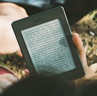 A smiling person using a tablet to read a product review outdoors.