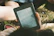 Man happily using a tablet outdoors, enjoying the ebook content.