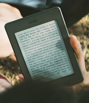 person holding black Amazon Kindle e-book reader