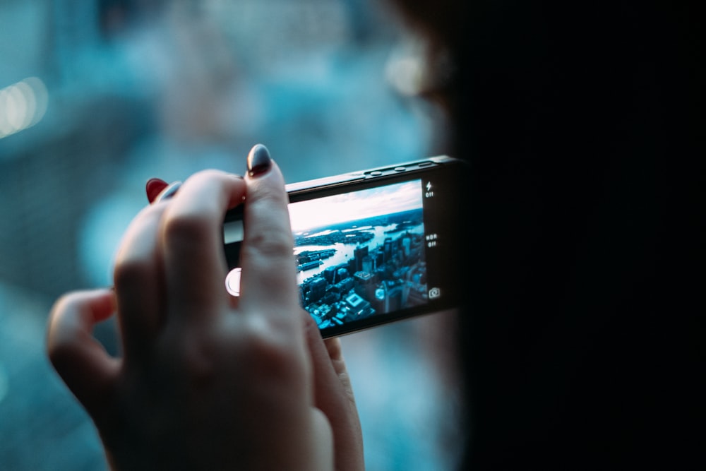 Persona sosteniendo un teléfono inteligente negro