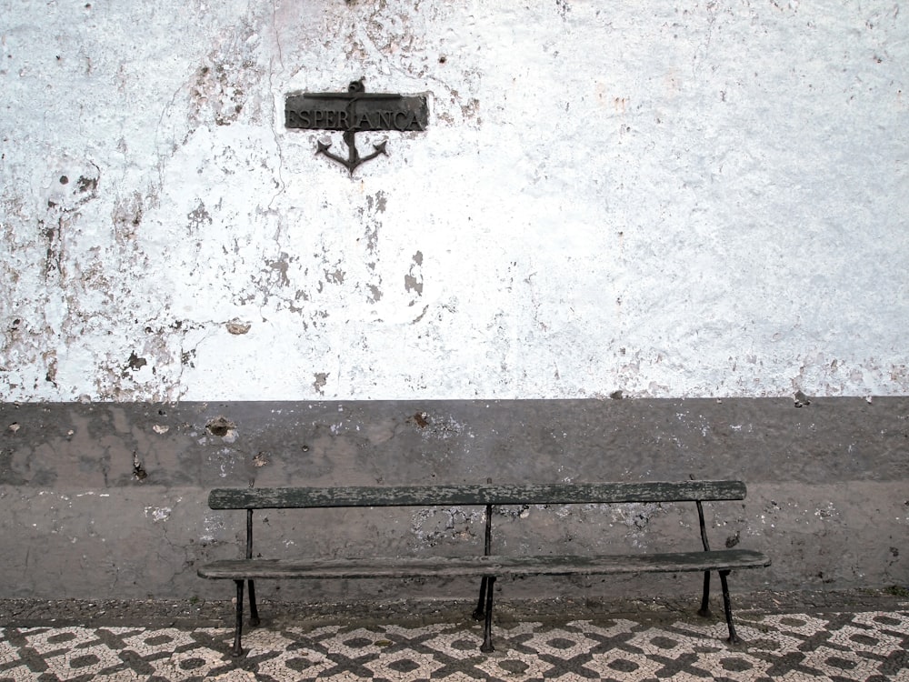 brown steel bench beside wall