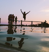 man jump in mid air on body of water