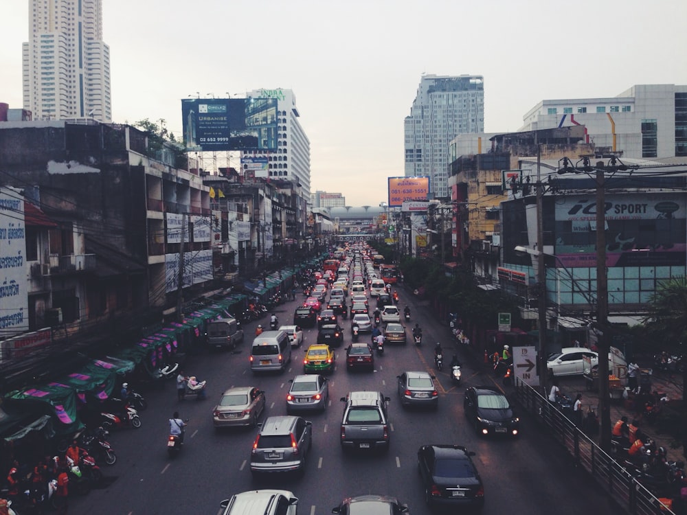 assorted cars on asphalt road beside buildings