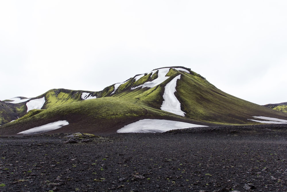 green mountain under white sky