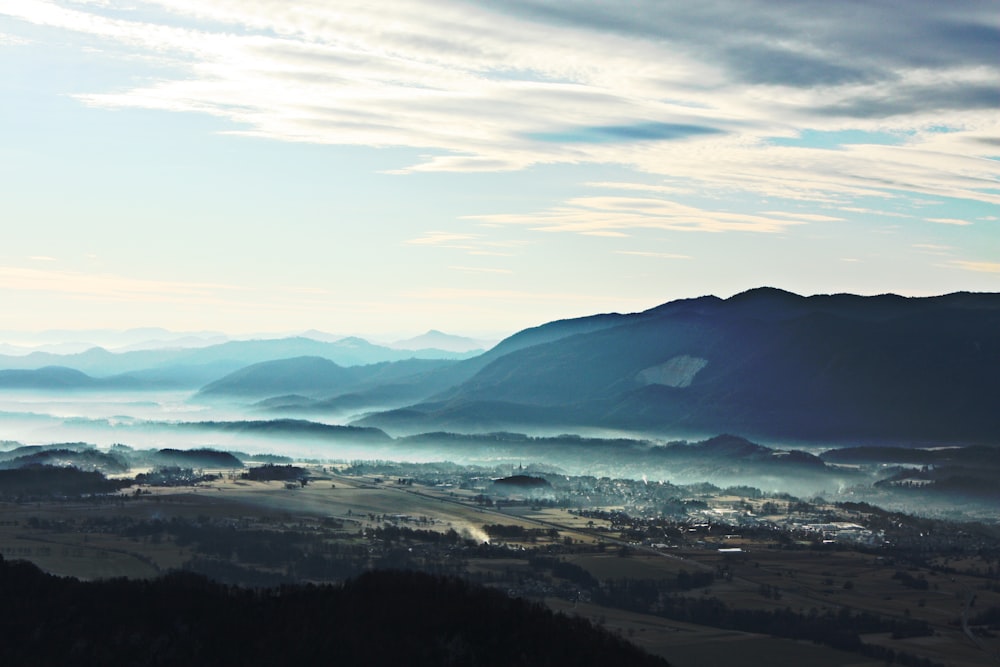 Edifici vicino alla montagna sotto cieli nuvolosi blu