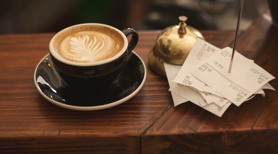 black ceramic cup with saucer and cappuccino on brown wooden surface