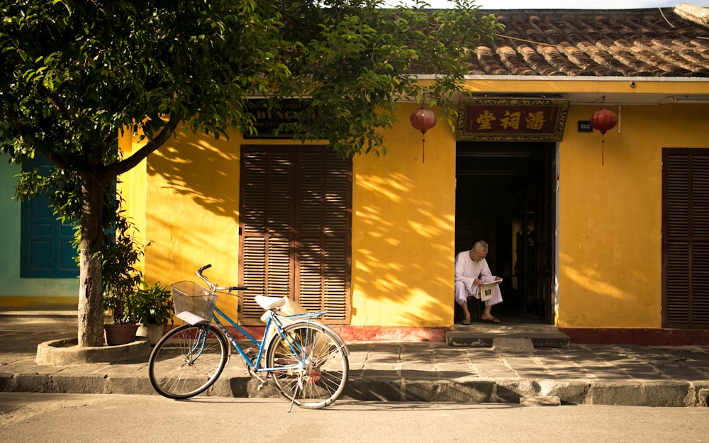 man sitting near door way reading paper