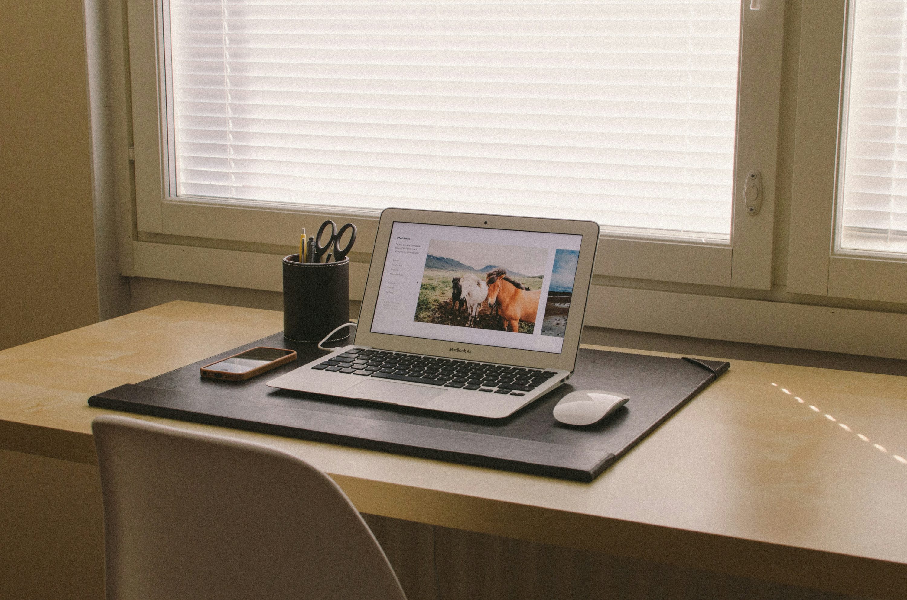 베이지색 나무 책상 위에 MacBook을 켰습니다.