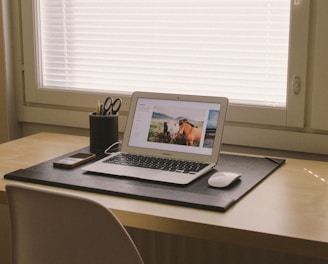 turned on MacBook on beige wooden desk