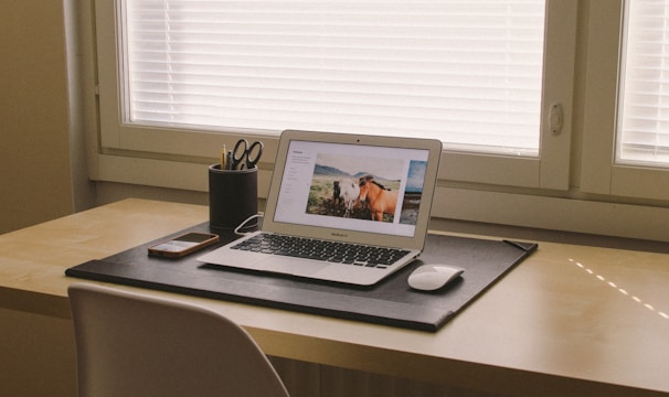 turned on MacBook on beige wooden desk