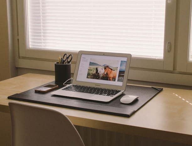 turned on MacBook on beige wooden desk