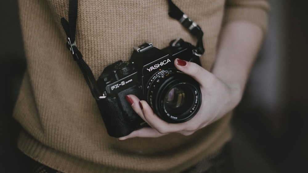 person holding black Yashica FX-9 camera