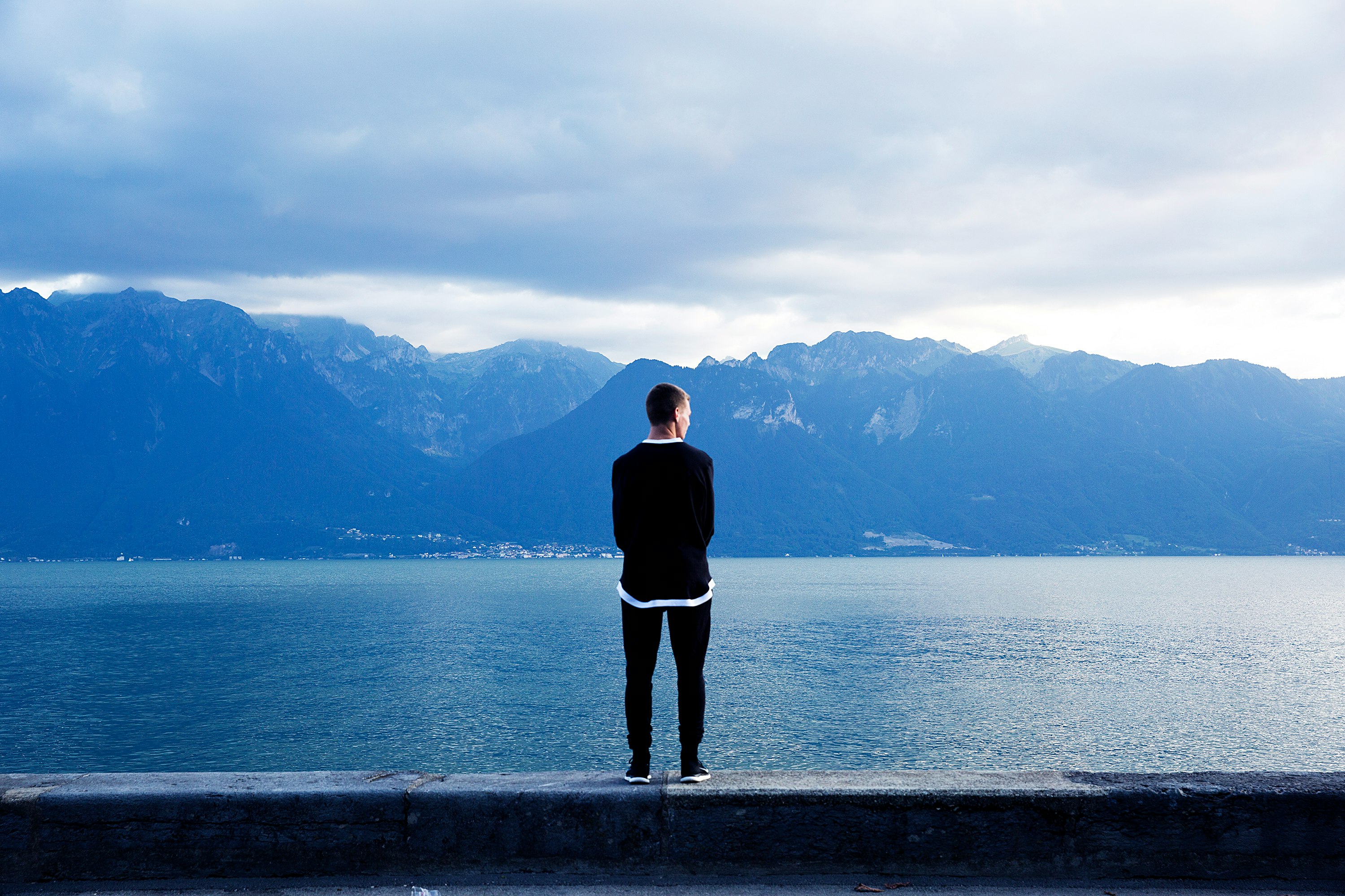 person wearing black pants and top standing on wall