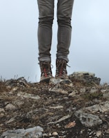 Hiker wearing durable boots stepping lightly over rocky terrain at dawn.