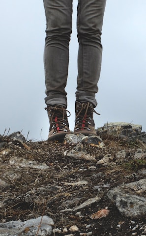 Hiker wearing durable boots stepping lightly over rocky terrain at dawn.